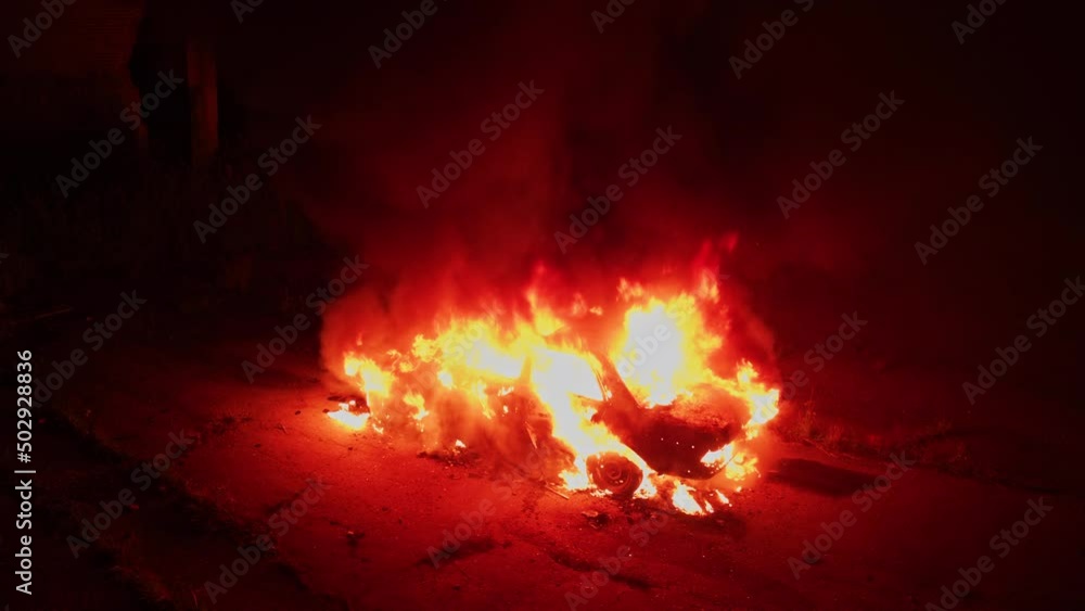 Car on fire. Accident. Spectacular night scene of burning old car explosion. Filming area. Horror thriller movie decoration. Aerial drone flight. Car on fire. Accident. Spectacular night scene of burning old car explosion. Filming area. Horror thriller movie decoration. Aerial drone flight.