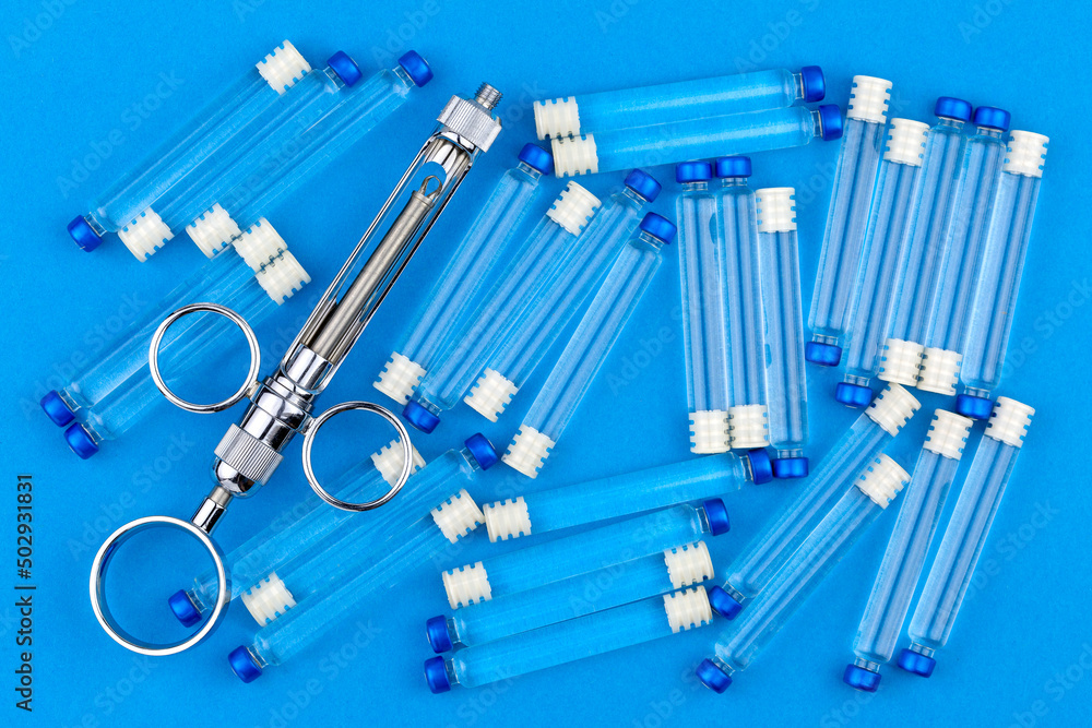 Metal syringe for local anesthesia and many carpules with anesthetic on