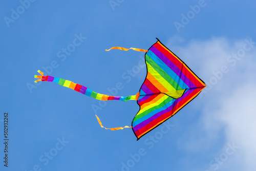 Kite in LGBT colors on a background of blue sky.