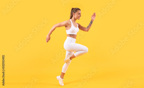 fitness girl runner running on yellow background
