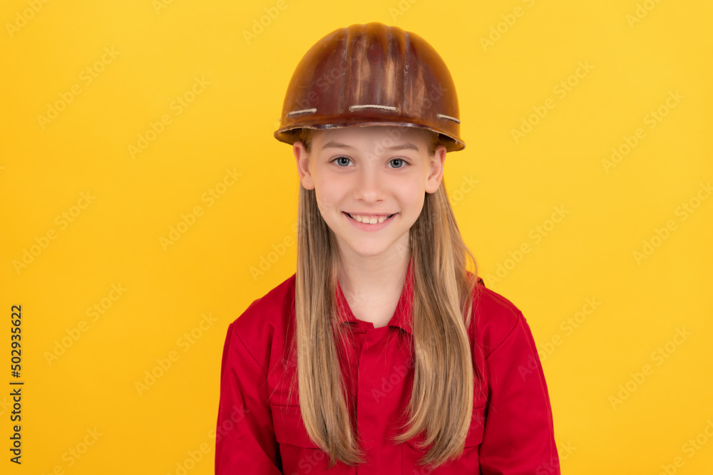 cheerful teen child in builder helmet on yellow background cheerful teen child in builder helmet on yellow background