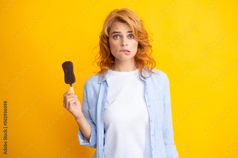 Summer concept. Funny woman holds tasty frozen ice cream, enjoys eating delicious cold dessert, poses on yellow background, feels happy. Summer concept. Funny woman holds tasty frozen ice cream, enjoys eating delicious cold dessert, poses on yellow background, feels happy.
