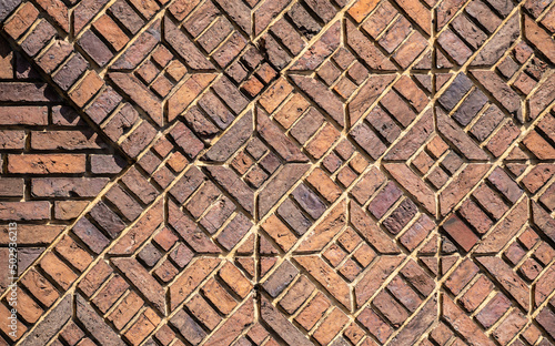 Background of a large number of dark red bricks laid in beautiful geometric patterns