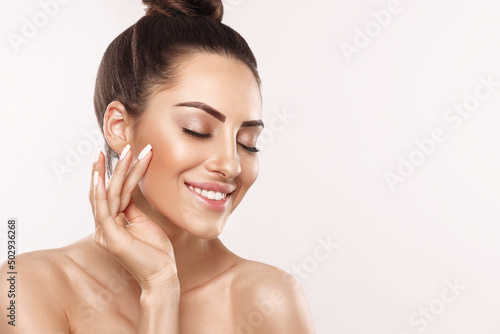 Portrait of woman with beauty face and perfect skin on gray background. Skin care. Cosmetology, beauty and spa