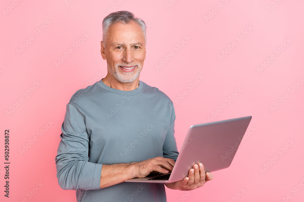 Photo of sweet pretty retired man wear grey shirt reading modern gadget empty space isolated pink color background Photo of sweet pretty retired man wear grey shirt reading modern gadget empty space isolated pink color background