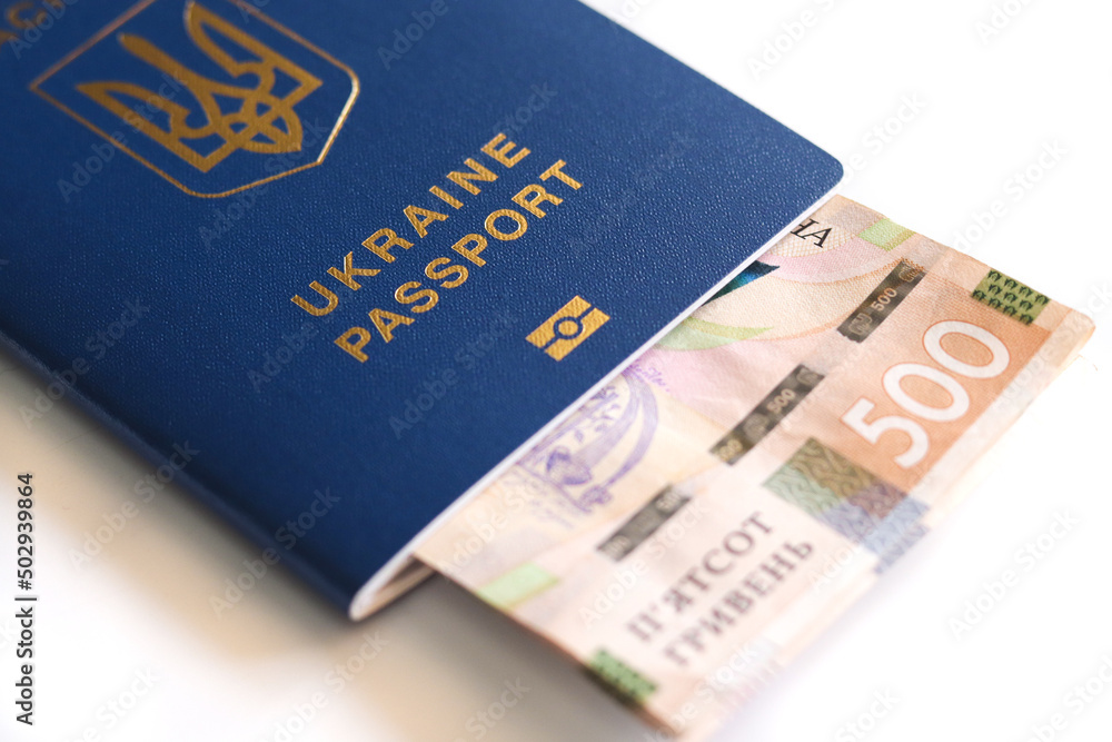 Ukrainian biometric passport. Ukrainian international passport with money inside isolated on a white background. Ukrainian biometric passport. Ukrainian international passport with money inside isolated on a white background.