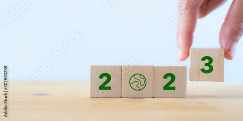 2023; Green business, enviromental sustainability. Carbon offset and neutrality strategies. 2023 written on wooden cubes and green community. Goals,plan,opportunity, new green business and social.