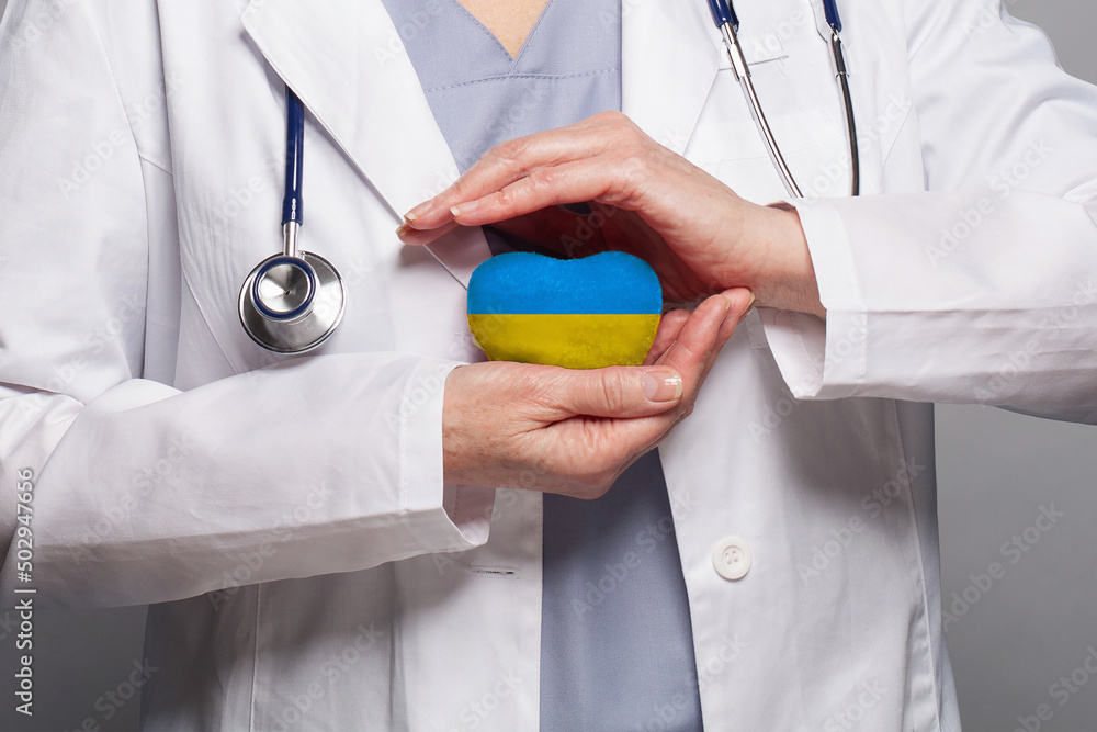 Doctor hands holding and caring heart with color of the Ukraine flag. Concept safety, health care and medicine in Ukraine - obrazy, fototapety, plakaty 