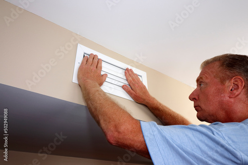Both Hands on Closed Air Vent to Reduce Air Circulation Register