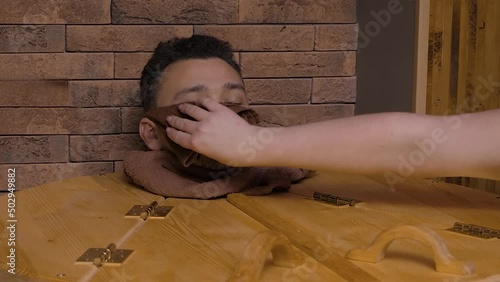 Female hands dry male head with towel in cedar hot herbal barrel in a spa salon. Handsome middle-aged man takes a sauna with healing effect and enjoys the process of phytobarrel photo