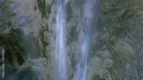Stream water falling in deep dark gorge waterfall