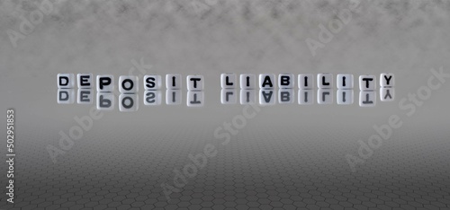 deposit liability word or concept represented by black and white letter cubes on a grey horizon background stretching to infinity
