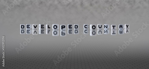 developed country word or concept represented by black and white letter cubes on a grey horizon background stretching to infinity