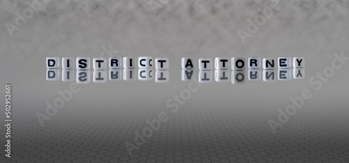 district attorney word or concept represented by black and white letter cubes on a grey horizon background stretching to infinity
