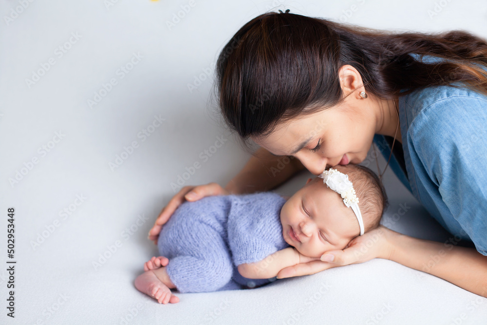 Beautiful young mother with a newborn daughter in a diaper on a white background. Motherhood. Tenderness. Space for text. Beautiful young mother with a newborn daughter in a diaper on a white background. Motherhood. Tenderness. Space for text.