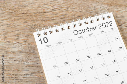 October 2022 desk calendar on wooden background.