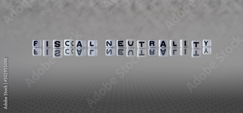 fiscal neutrality word or concept represented by black and white letter cubes on a grey horizon background stretching to infinity