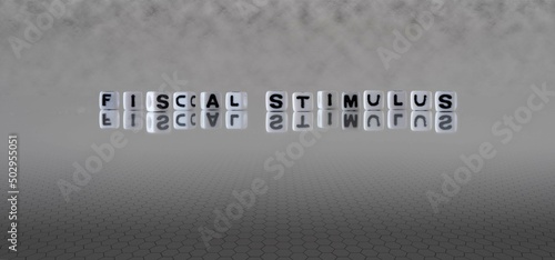 fiscal stimulus word or concept represented by black and white letter cubes on a grey horizon background stretching to infinity