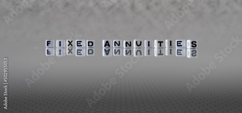 fixed annuities word or concept represented by black and white letter cubes on a grey horizon background stretching to infinity photo