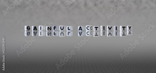 Fotografie gainful activity word or concept represented by black and white letter cubes on
