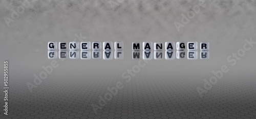 general manager word or concept represented by black and white letter cubes on a grey horizon background stretching to infinity