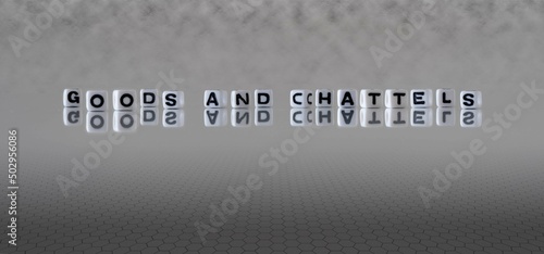 goods and chattels word or concept represented by black and white letter cubes on a grey horizon background stretching to infinity