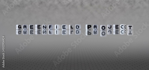 greenfield project word or concept represented by black and white letter cubes on a grey horizon background stretching to infinity