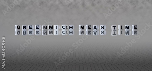 greenwich mean time word or concept represented by black and white letter cubes on a grey horizon background stretching to infinity