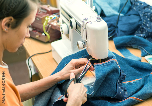 Sustainable living and fashion. A woman is sewing second-hand. Waste-free living and reuse