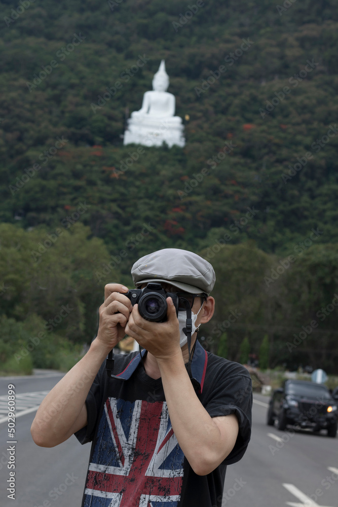 Obraz premium An adult is taking pictures with a camera in a tourist attraction with a stern expression.