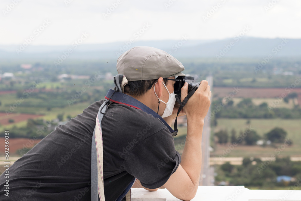 An adult is taking pictures with a camera in a tourist attraction with a stern expression.