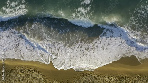 Above view of rough ocean waves crashing on empty deserted beach