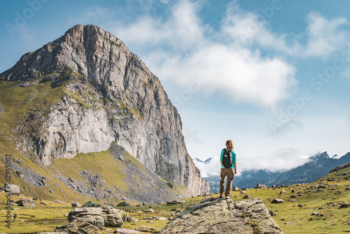 Young Woman With A Backpack on The Top Of a rock in a Beautiful wild Landscape. Discovery Travel Destination Concept