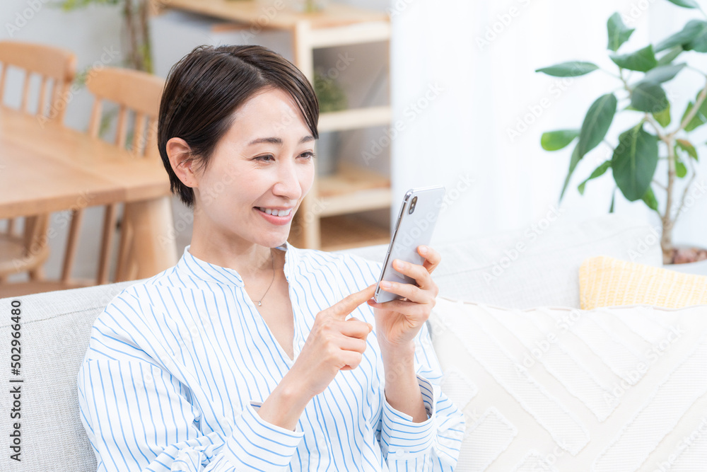 ソファーに座るミドル女性(スマホ・メール・インターネット) ソファーに座るミドル女性(スマホ・メール・インターネット)