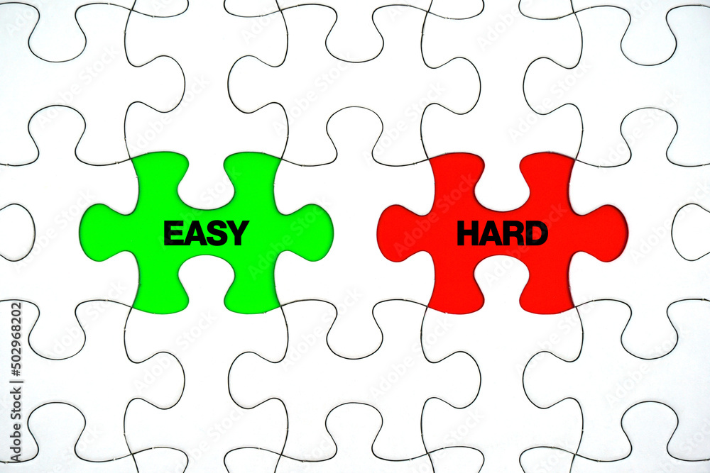 Hard and Easy words on pieces paper puzzle. To make a choice between the options of easy or hard way concept. Hard and Easy words on pieces paper puzzle. To make a choice between the options of easy or hard way concept.