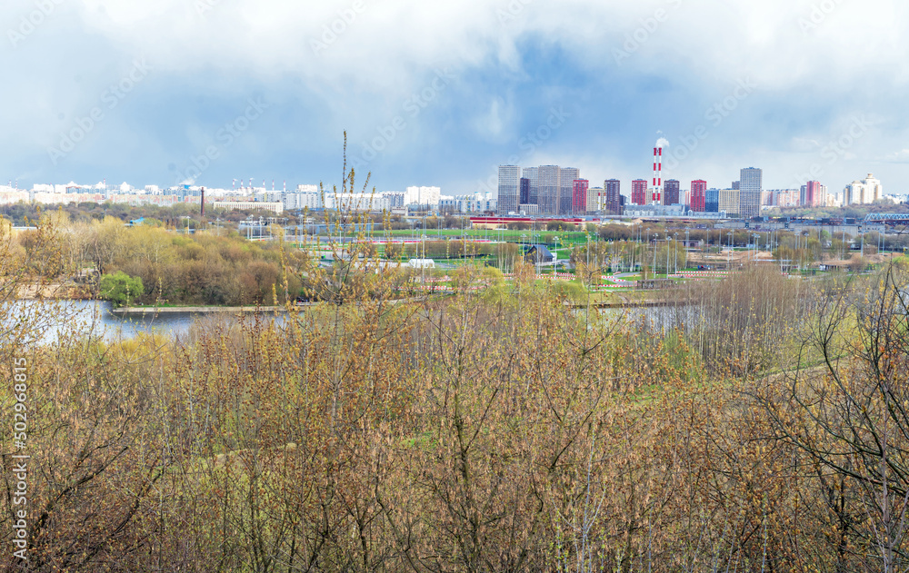 Landscape with spring park, river and Moscow new buildings in the background.