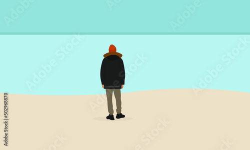 A male character in a jacket and hat stands on the beach and looks at the water photo