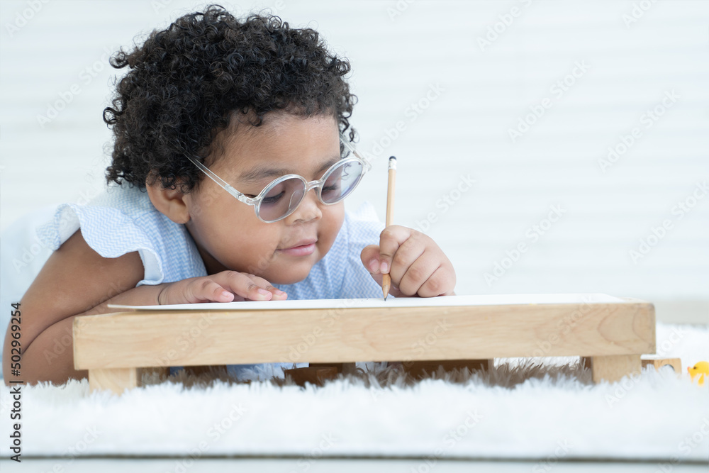 Portrait of Little cute African chubby kid girl wear glasses use left