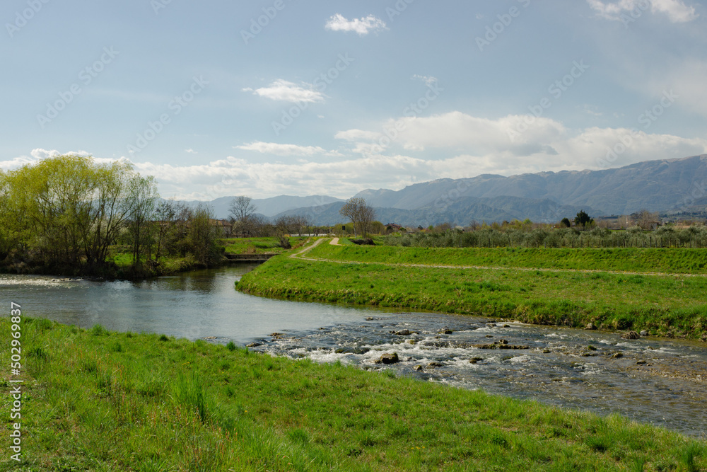 Italian rural landscape. Meschio River with hills in the background. Cordignano, Treviso, Italy.