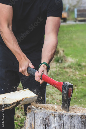 Strong man chopping firewood outdoors