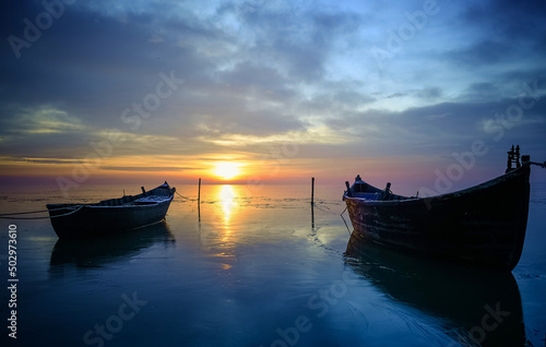 fishing boats in winter on the lake at sunrise