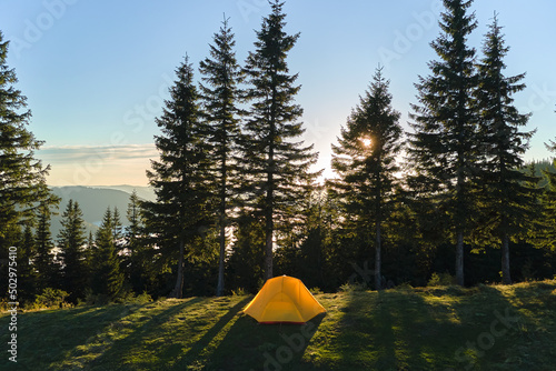 Aerial view of tourist camping tent on mountain campsite at bright sunny evening. Active tourism and hiking concept