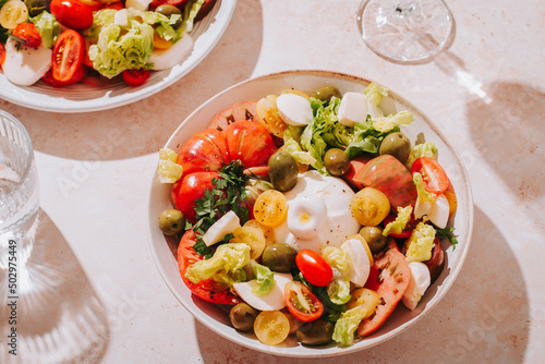 Fresh mediterranean salad with tomatoes and burrata cheese, top view