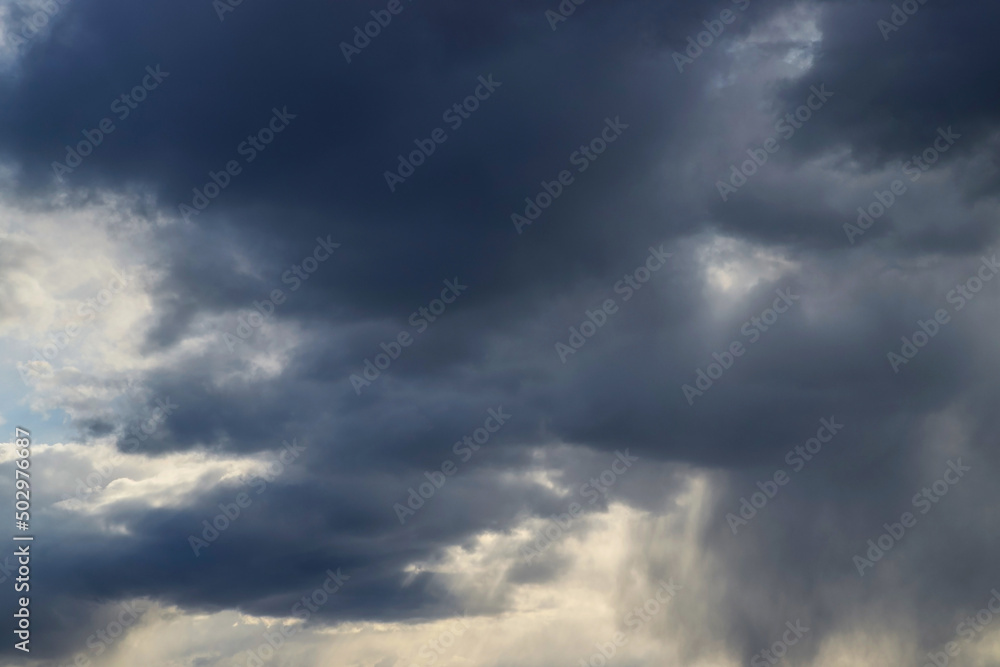 Dark thick blue clouds in the evening sky. Dramatic cloudscape. Nature background