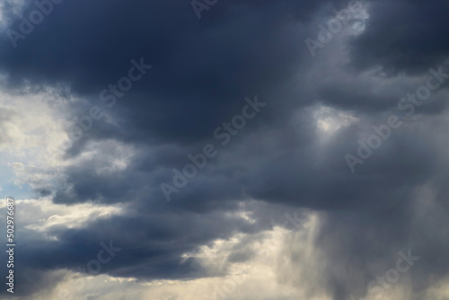 Dark thick blue clouds in the evening sky. Dramatic cloudscape. Nature background