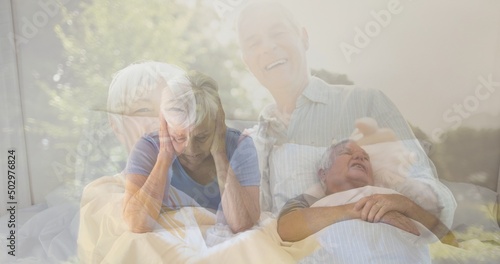 Happy caucasian senior couple in park and senior woman closing ears while man snoring on bed at home © vectorfusionart
