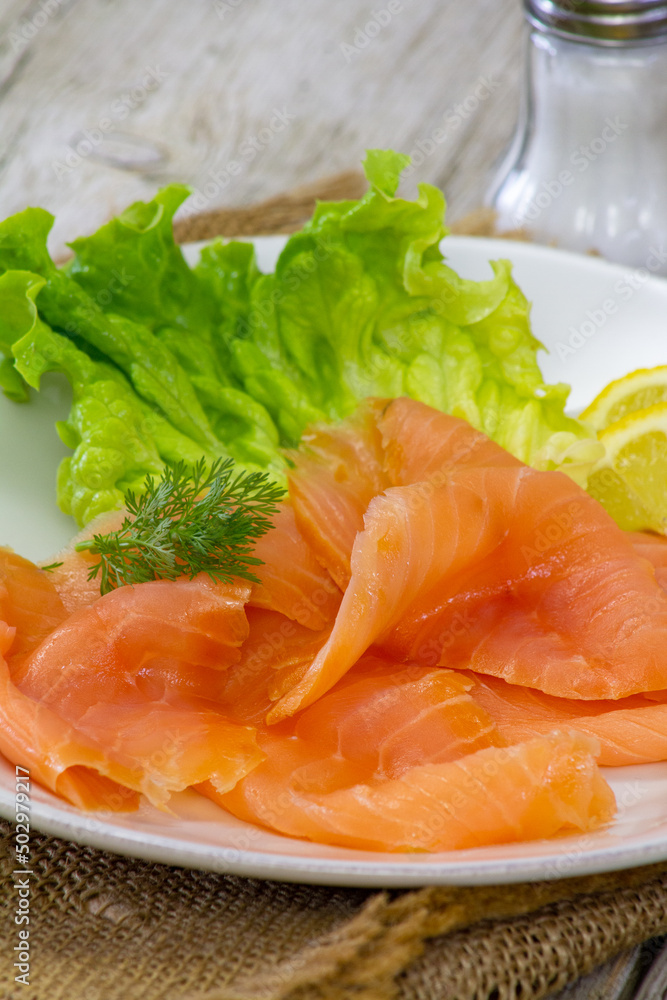 sliced salmon with green lettuce leaves sliced salmon with green lettuce leaves