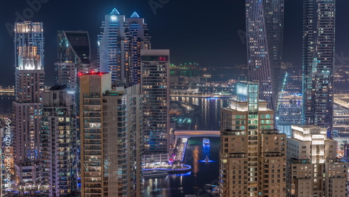 Promenade and canal in Dubai Marina with luxury skyscrapers around night timelapse, United Arab Emirates