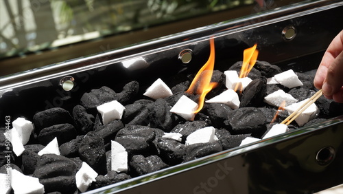 Empty Barbecue Flaming Grill Close Up With Bright Flames And White firelighters burning photo