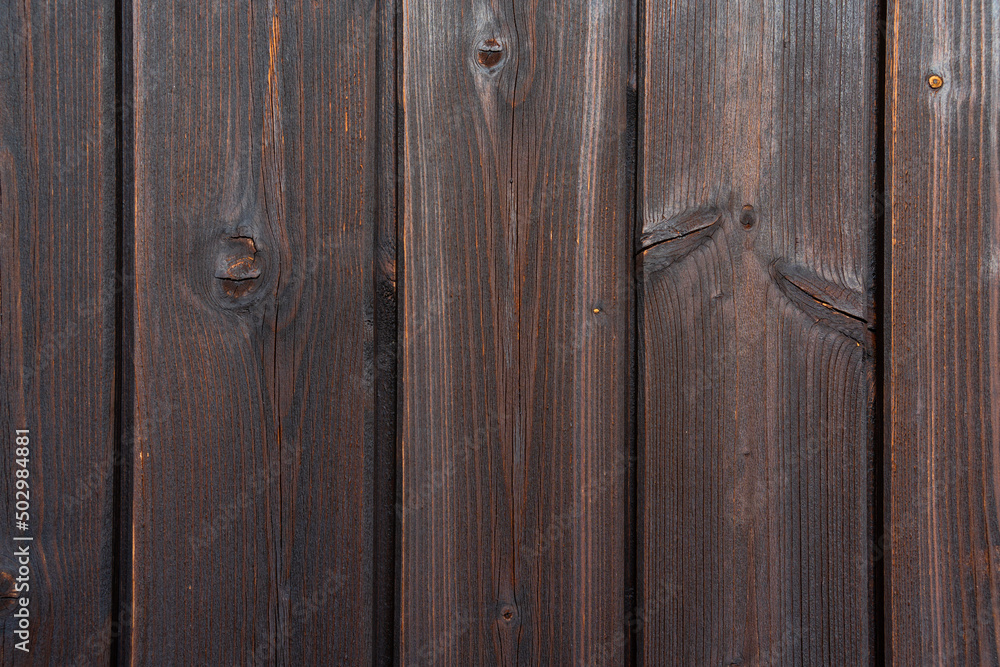 Old brown rural wooden wall on a balcony in dark colors, detailed image texture. Natural wooden building structure, background. Suitable as a flatlay. Old brown rural wooden wall on a balcony in dark colors, detailed image texture. Natural wooden building structure, background. Suitable as a flatlay.